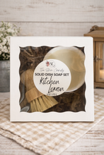 Load image into Gallery viewer, Solid dish soap set with a wooden scrubber and lemon scent packaging on a wooden surface.